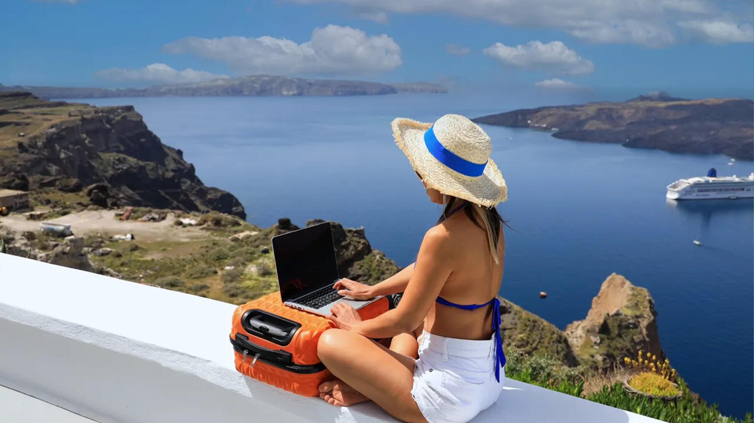 Yunanistan dijital göçebe vizesiyle uzaktan çalışan kişi Santorini manzarasında çalışıyor